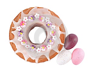 Festively decorated Easter cake and painted eggs on white background, top view