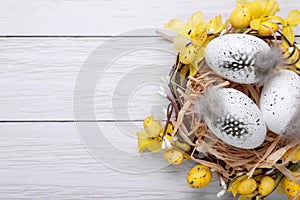 Festively decorated Easter eggs on white wooden table, top view. Space for text