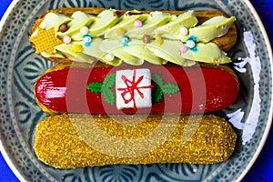 Festively decorated eclairs in New Year's style 2022 lying on round gray plate.