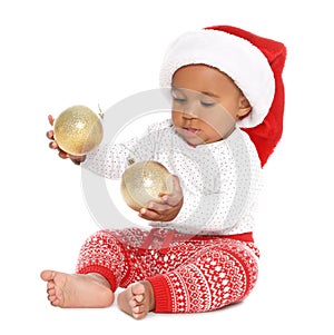 Festively dressed African-American baby with Christmas decorations on background