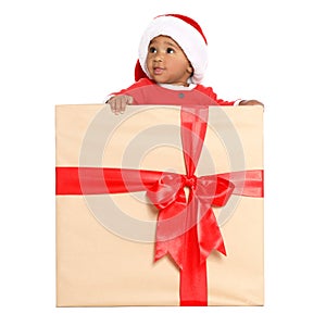 Festively dressed African-American baby in Christmas gift box on background