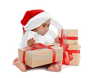 Festively dressed African-American baby with Christmas gifts