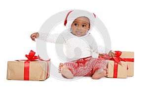 Festively dressed African-American baby with Christmas gifts on white