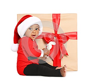 Festively dressed African-American baby with toy near Christmas gift