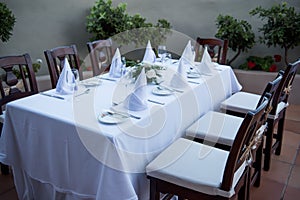 Festively laid table with white tablecloths glasses and plates