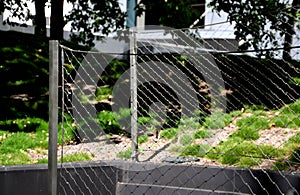 Wire stainless steel net made of ropes connected by metal connectors as a fence filling, loops, rope connectors, protective photo