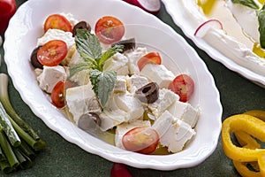 Feta cheese cut in cubes, with mint, cherry tomatoes and olives