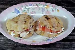 Feta white cheese with slices of tomatoes inside a mini traditional Egyptian flat bread with wheat bran and flour, small Aish
