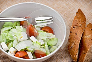 Fetta salad portion and slices of whole wheat bread photo