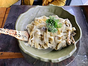 Fettuccine Alfredo Pasta Dish with Cream, Chicken and Parsley served at Restaurant.