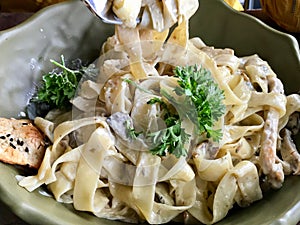 Fettuccine Alfredo Pasta Dish with Cream, Chicken and Parsley served at Restaurant.