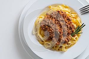 Fettuccine with bolognese sauce or ragu bolognese and rosemary, top view
