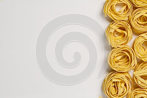 Fettuccine italian pasta isolated on white background. Raw tagliatelle nests isolated on white background. Traditional