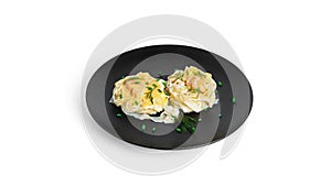 Fettuccine pasta with shrimp in cream sauce on black plate isolated on a white background. Nests of pasta with seafood