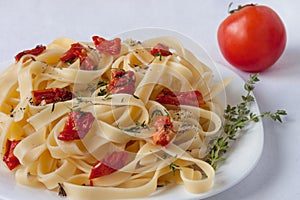 Fettuccine pasta with sun-dried tomatoes and rosemary. Close up