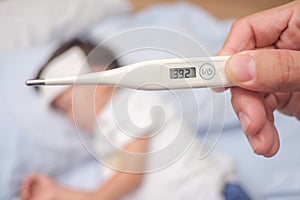 Fever, Close-up medical thermometer, Parent / Father measuring temperature of his ill kid, Asian 3 - 4 years old toddler boy gets