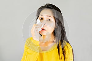 Fever,Young Asian woman wearing yellow shirt,Have a cold, wipe the snot  on gray background,health care concept