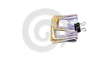 Few bangladeshi thousand taka banknotes attached with a black binder clip on white background with copy space