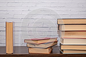 A few books of various sizes arranged on a dark wooden shelf