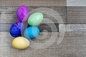 A few bright easter eggs on the wooden background
