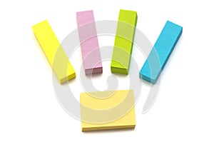 A few bright fluorescent colored self adhesive paper memo pads white backdrop