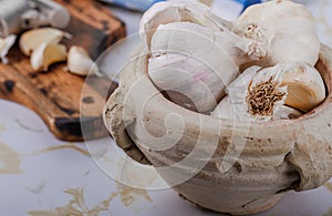 A few bulbs of garlic in a clay pot.