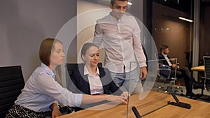 Few businesspeople, male and 2 women, work with modern future transparent glass interface display.