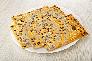 Few cookies with sunflower seeds, flaxseeds and sesame in plate on table