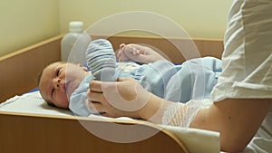 Few days old newborn baby on the table in hospital with mother