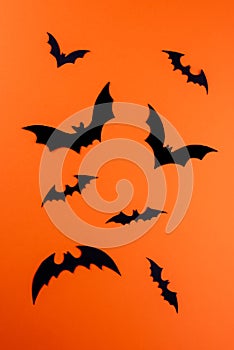 Black paper bats on vertical orange background