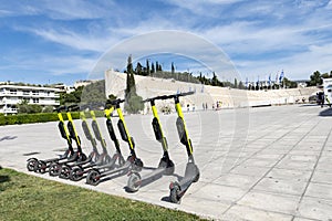 Few electric scooters parked in the sidewalk