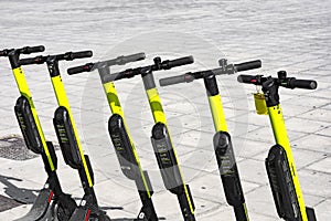 Few electric scooters parked in the sidewalk