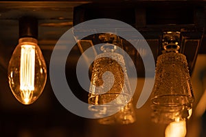 A few geometric glass goblets for alcoholic drinks, cocktails, wine, champagne, martini hang upside down above the bar. Warm eveni