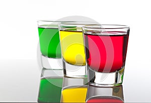 A few glasses of alcoholic drinks in red green yellow