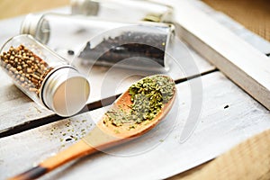 A few grams of dried Basil on a wooden tray coriander and dried berries