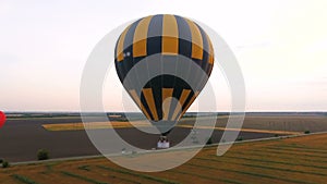 Few hot air balloons flying over fields, road running amidst, industrialization