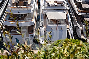 A few of huge moored yachts are in port Hercule of Monaco at sunny day, Monte Carlo, interiors of motor boat, chilling