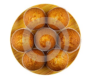 Few muffins in paper mold on plate isolated on white background. Top view