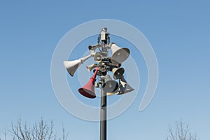 A few old retro vintage announce speakers that installing at the peak of pole in local downtown village, with blue sky