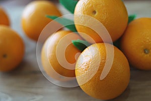 A few oranges with a heart aign made of close seeds in a gray bowl closeup on an old wooden backdround in brown with a blurred bac