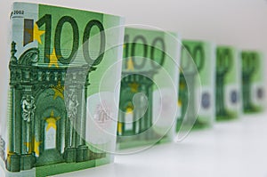 A few paper currencies in one hundred euros located on a white background.