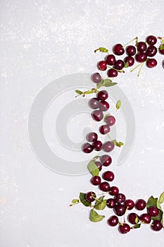 A few ripe cherries on a gray textured background, top view photo