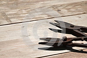 A few rusty scissors for metal lies on a wooden table in a works