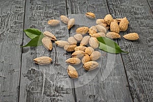 A few shelled almonds on a black wooden table