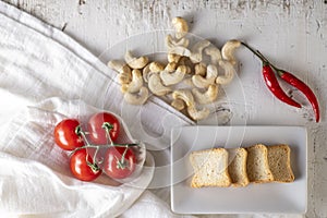 Few tomato and kaju over a white table