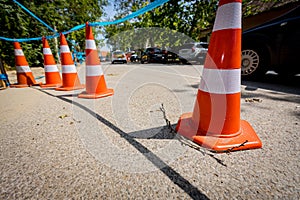 Few traffic cones tied, connected, with blue warning tape