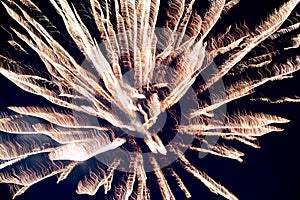 A few volleys of festive fireworks in the night sky, red-yellow.