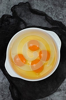 few yellow egg yolks in a white bowl