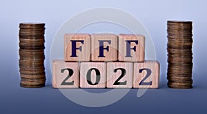 FFF 2022 - acronym on wooden cubes on a light background with coins