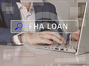 FHA LOAN Federal Housing Administration text in search bar. Businessman looking for something at laptop. FHA LOAN Federal Housing